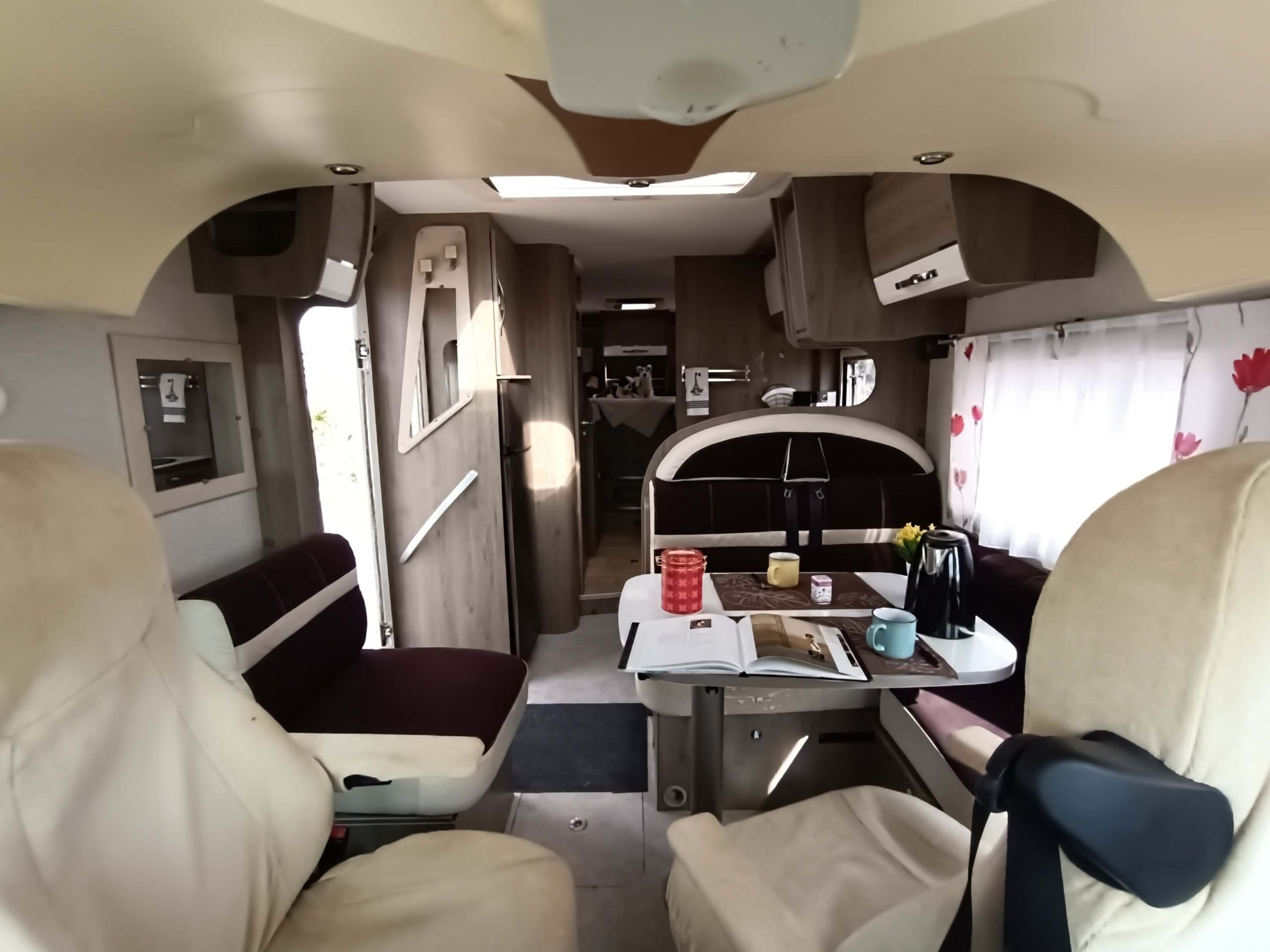 Salón y cocina autocaravana Bavaria Arctic I74 con asientos enfrentados y nevera trivalente